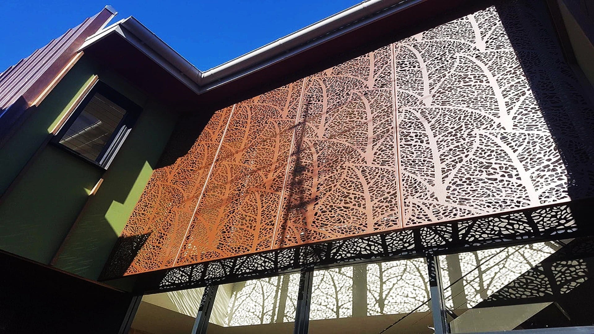 Luxury flagship store exterior with Champagne Gold PVD stainless steel laser cut cladding.