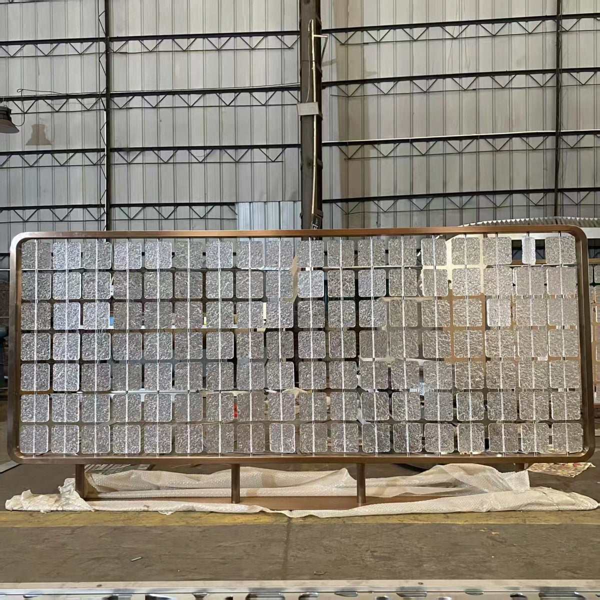 Bronze stainless frame glass-hybrid screen with textured glass panels in our workshop.