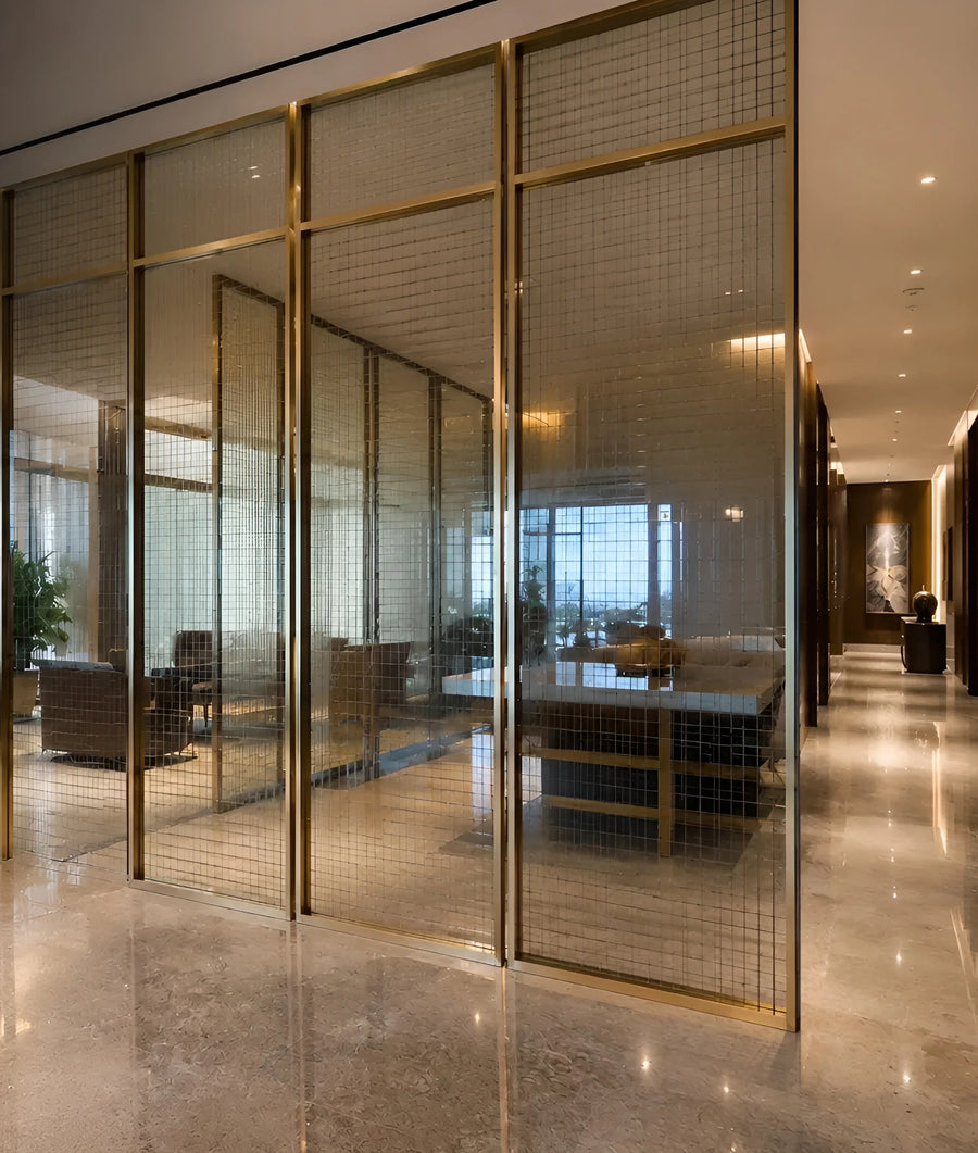 Champagne-toned steel framed wired-glass partition screens enclosing a corporate reception lounge in Singapore