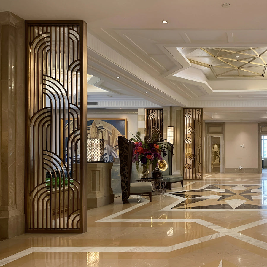 Rose gold PVD heritage lattice screen in a hotel lobby — visualization