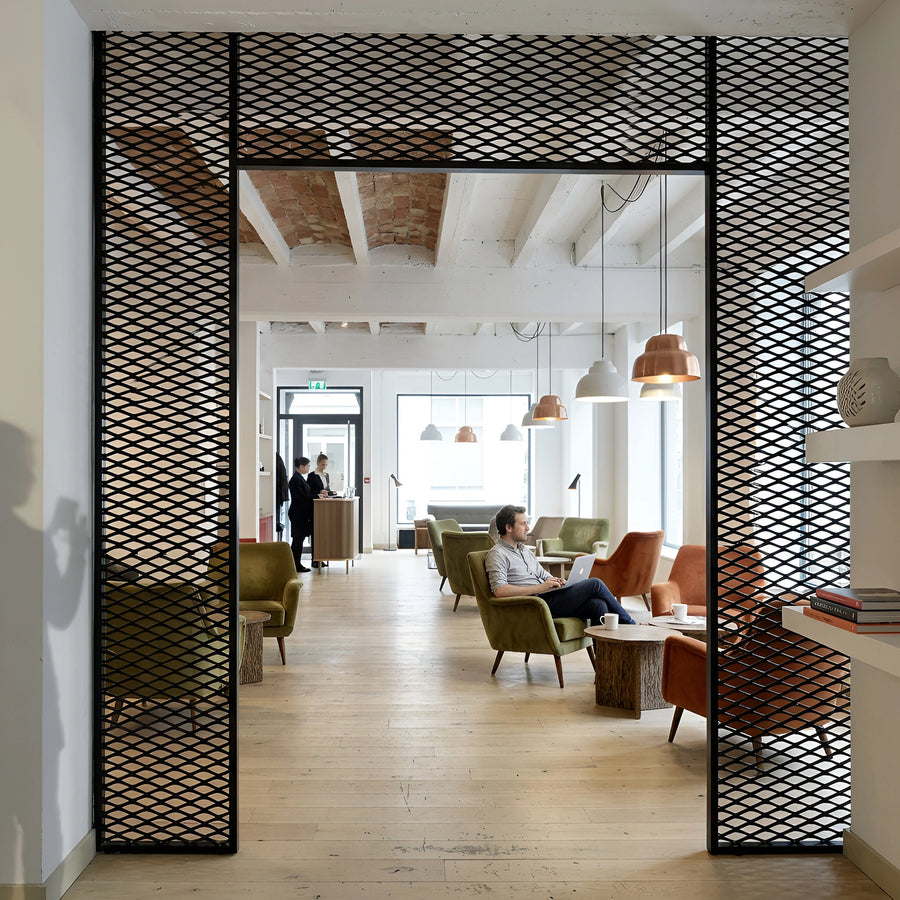 Black expanded diamond mesh partition screens zoning a hotel lobby lounge — visualization
